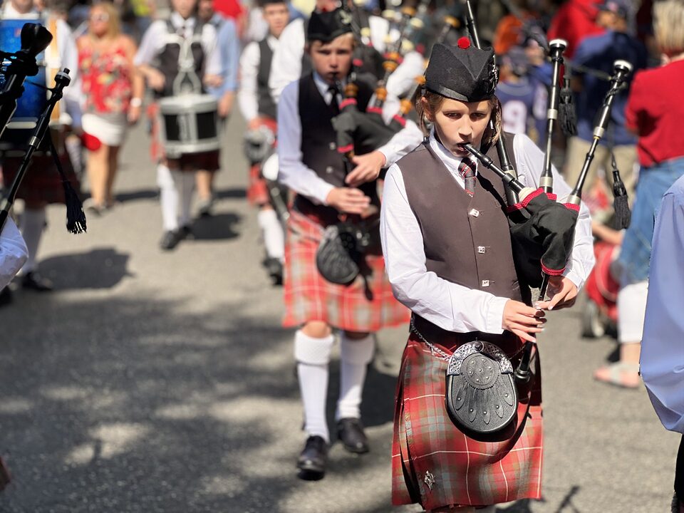 Charlotte Burslem in full Highland dress playing the bagpipes